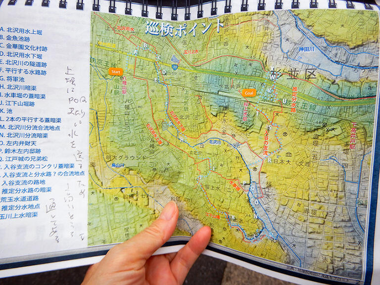 北沢川（青い線）と北沢用水（赤い線）は、北西から東南（A地点からM地点）へ続く谷を流れていた。京王線の線路の北側に甲州街道が通り、さらにその北を玉川上水が流れている