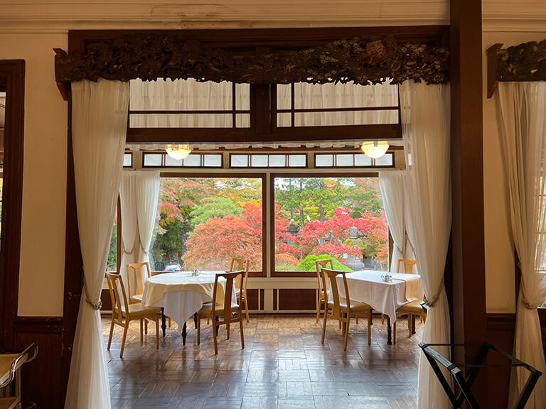 大きな窓から紅葉を見るメインダイニングルーム