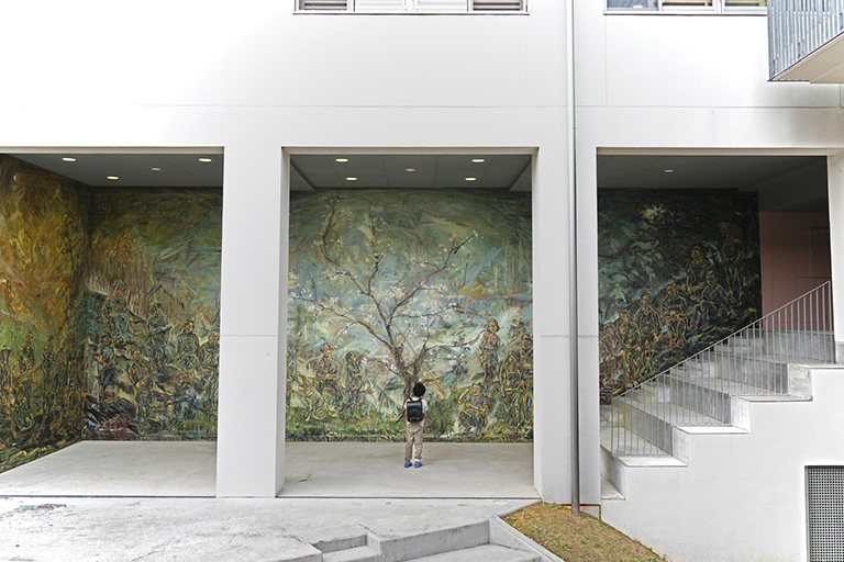 壁画No.0「HIGHLIGHT | ハイライト」。雄勝小・中学校の壁に、「奇跡の桜」と呼ばれる桜の木と当時の在校生徒33名を描いた（写真提供：海岸線の美術館）