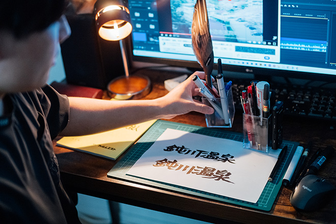 西井さんのデスク。編集デスクにカッターボード、紙、ペンなどの筆記用具が充実しているのが、ほかの動画クリエイターと違うところ